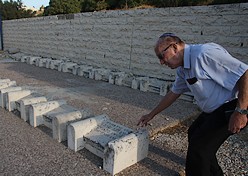 8-18-09 pic gravestones Shlomo Slonim, 81, lays a stone on his mother's grave, which is just one in a number of rows of graves from Hebron massacre. Photo: Tovah Lazaroff