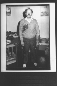 Police photo of Palestinian emigre grocer Zein Isa, wearing blood-stained sweater, with bloodied hands, standing at home after he stabbed his 16-year-old daughter Tina to death.