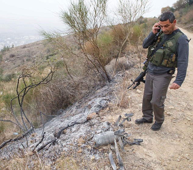 An Israeli regional security officer stands looks over the rocket's debris. Relations between the two countries had been relatively peaceful until Dec 29 attacks.