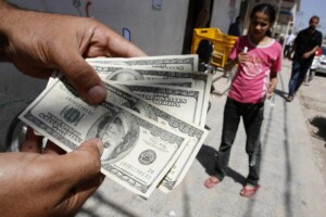 ATM A Palestinian man employed by Fatah displays his money after an ATM withdrawal at the Bank of Palestine in Rafah, southern Gaza Strip on June 8, 2012. Photo: Abed Rahim Khatib / Flash 90