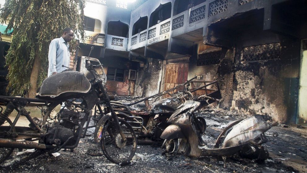 A man observes the remains of destroyed vehicles and buildings in the town of Mpeketoni, Kenya, following an attack, June 16, 2014. / AP Photo