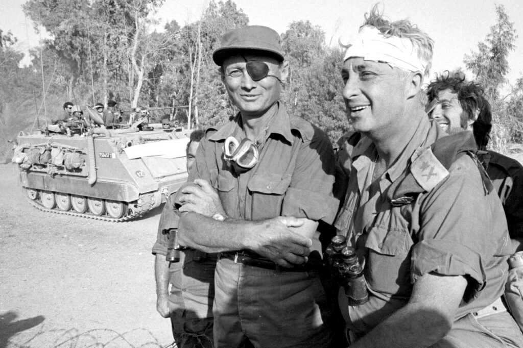 In October 1973, future Israeli Prime Minister Ariel Sharon helped turn the tide of the fourth Arab-Israeli war after a surprise attack by Egypt and Syria, eventually encircling the Egyptian Third Army. Mr. Sharon (right), recovering from a head injury, stands with Israeli Defense Minister Moshe Dayan on the western side of the Suez Canal.