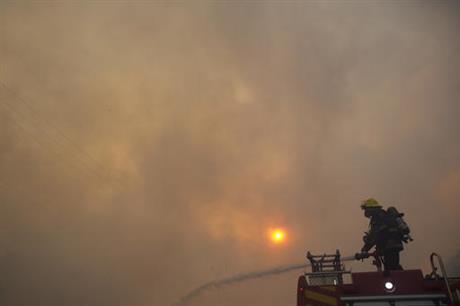 A Firefighter works at the site of wildfires in Haifa, Israel, Thursday, Nov. 24, 2016. A raging wildfire ripped through parts of Israel's third-largest city on Thursday, forcing tens of thousands of people to evacuate their homes and prompting a rare call-up of hundreds of military reservists to join overstretched police and firefighters. Spreading quickly due to dry, windy weather, the fire quickly spread through Haifa's northern neighborhoods. While there were no serious injuries, several dozen people were hospitalized for smoke inhalation. (AP Photo/Ariel Schalit)