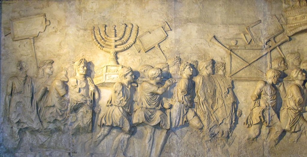 In Rome, any present-day tourist can behold, on the ancient Arch of Titus, the engraved likeness of the Jewish candelabra (Menorah), which the Romans brought back from Jerusalem after ransacking the Jewish Temple. Pictured: Photo of a panel copy from the Arch of Titus, displayed in the Beth Hatefutsoth museum in Israel. (Image source: Wikimedia Commons/Sodabottle)
