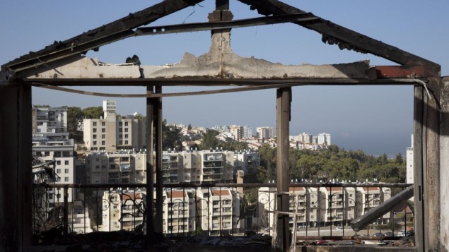 The Mediterranean sea and parts of the city can bee sen through a burned house following wildfires in Haifa, Israel, Friday, Nov. 25, 2016. (AP Photo/Ariel Schalit)